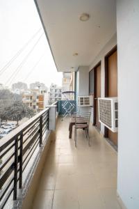 einen Balkon mit einem Tisch und Stühlen darauf in der Unterkunft The Lodgers 2 BHK Serviced Apartment infront of Artemis Hospital Gurgaon in Gurgaon