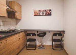 a kitchen with two bar stools and a counter at Dżolanda Pokoje in Milsko +6 photos