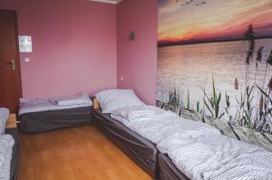 2 Betten in einem Zimmer mit Wandgemälde in der Unterkunft Dżolanda Pokoje 