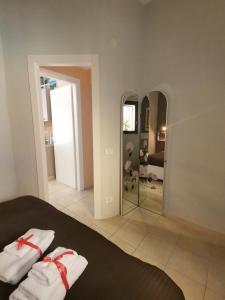 een slaapkamer met een bed met 2 witte handdoeken en een spiegel bij O SOLE MIO in Agrigento