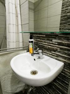 lavabo blanco en el baño con espejo en Apt 100 Prague, en Praga