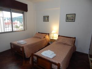 2 camas en una habitación con ventana en Departamento temporario en Salta