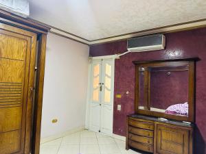 um quarto com uma cómoda de madeira e um espelho em 84 شارع الجليل جسر السويس no Cairo