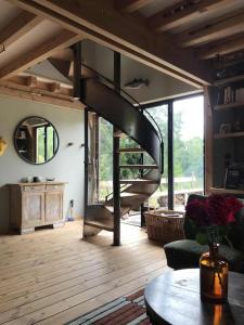 a living room with a spiral staircase in a house at La cabane de l'étang in Feings