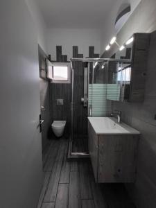 uma casa de banho com um lavatório, um chuveiro e um WC. em Villa Sakrakis seaview villa em Stavros
