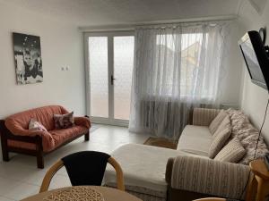 a living room with a couch and chairs and a window at Friends Villa Apartments 2 in Hévíz