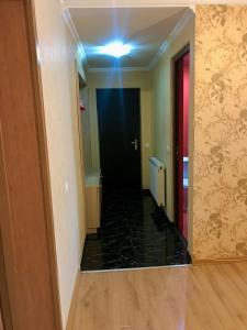 einen Flur mit schwarzer Tür und schwarzem Marmorboden in der Unterkunft Homee in Tbilisi City