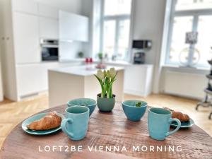 - une table avec des tasses et des croissants dans la cuisine dans l'établissement Loft2Be, Vienna City Loft for 8, à Vienne