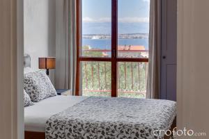 a bedroom with a bed and a large window at Villa Marcela in Preko