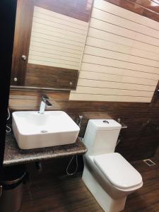 a bathroom with a white sink and a toilet at Belair Resorts in Kotagiri