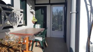 a porch with a wooden table and chairs and a door at INIGO in Hendaye