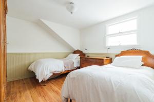 Schlafzimmer im Dachgeschoss mit 2 Betten und einem Fenster in der Unterkunft Hummingbird House by Country House Escapes in Pine Hill