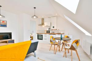 a kitchen and dining room with yellow chairs and a table at Little Cosy - T2 avec parking in Vierzon