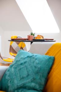 a couch with a pillow and a table with food on it at Little Cosy - T2 avec parking in Vierzon