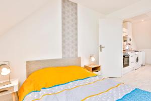 ein Schlafzimmer mit einem Bett mit einer gelben Decke in der Unterkunft Little Cosy - T2 avec parking in Vierzon
