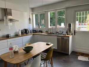 a kitchen with a wooden table and a table and chairs at Villa d'architecte in La Celle-Saint-Cloud