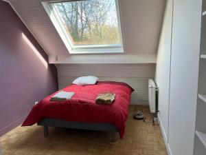 a small bedroom with a red bed with a window at Villa d'architecte in La Celle-Saint-Cloud
