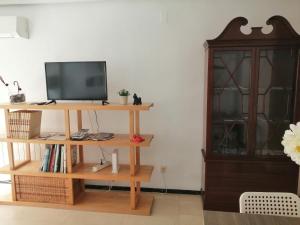 uma sala de estar com televisão numa prateleira de madeira em La Luna de Alicante em Alicante