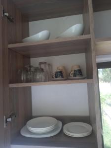 a pantry with plates and bowls on shelves at BreezHub Residence in Kikambala