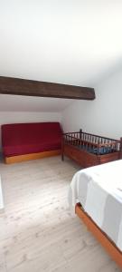 una camera con un letto e un divano rosso di Patios de la mer Villa à 200 m de la plage a Saint-Cyprien