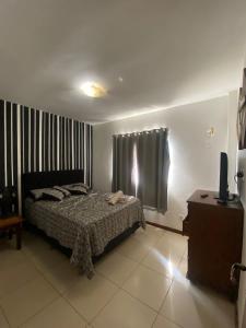 1 dormitorio con 1 cama y TV en Resort Villa da praia apto 30 arraial do cabo en Arraial do Cabo