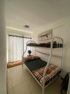 1 dormitorio con 2 literas y ventana en Resort Villa da praia apto 30 arraial do cabo en Arraial do Cabo