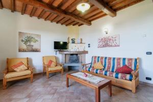 sala de estar con sofá, sillas y chimenea en Villa Perugini, en Tuoro sul Trasimeno