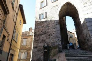 un arco in un edificio con scale in una strada di City Center “ Arco dei Gigli “ a Perugia