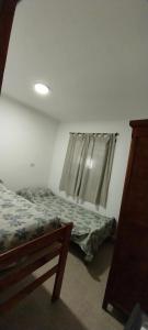 1 dormitorio con cama y ventana en El Quincho en Gualeguay