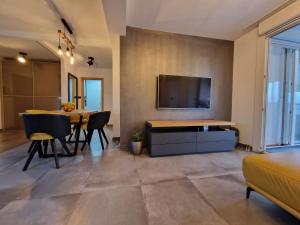 a living room with a table and a tv on a wall at Apartment Matea in Pula