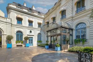 a large white building with a courtyard with potted plants at Santo Mauro, a Luxury Collection Hotel, Madrid in Madrid