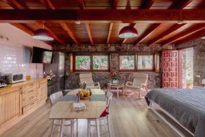 a bedroom with a bed and a table and chairs at Papaya Cottage Punta del Hidalgo in Punta del Hidalgo