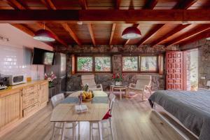 una camera da letto con un letto, un tavolo e delle sedie di Papaya Cottage Punta del Hidalgo La Azócar a Punta del Hidalgo