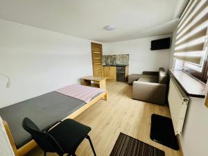 una piccola stanza con un letto e un divano di Apartamenty u Krystyny a Klikuszowa