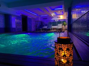 Silver Suites Hotel & Spa في الدار البيضاء: مسبح في بيت فيه اناره ازرق واخضر
