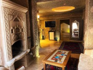 a living room with a fireplace and a table at Cappadocia Empire Cave Hotel in Goreme
