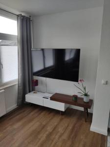 a living room with a large flat screen tv on the wall at Helle, offene Whg im Zentrum vom Ostseebad Göhren in Göhren