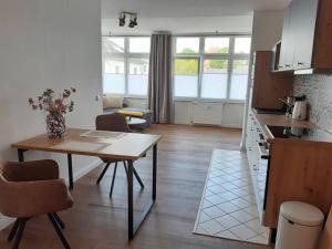 a kitchen and living room with a table and a dining room at Helle, offene Whg im Zentrum vom Ostseebad Göhren in Göhren