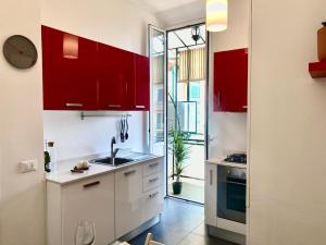 Una cocina con gabinetes rojos y un fregadero. en C&Y Apartments - Roma Vaticano St Peter - Luxe Penthouse Flat, en Roma 73 fotos más