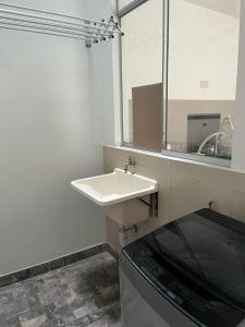 a bathroom with a white sink and a mirror at Ica tierra del sol eterno 2 in Ica