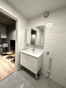 Baño blanco con lavabo y espejo en Staying, studio apt. 2 en Tromsø