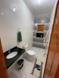 a bathroom with a sink and a toilet at Casa de Praia do Luiz in Luis Correia