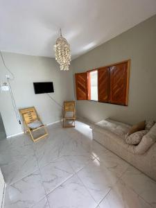 a living room with a couch and a tv at Casa de Praia do Luiz in Luis Correia