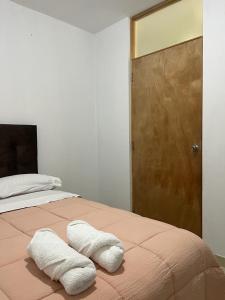 a bedroom with a bed with two towels on it at Ica tierra del sol eterno 2 in Ica