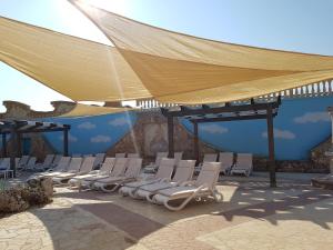 a row of lounge chairs under awning on a patio at Tenute Al Bano in Cellino San Marco