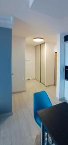 an empty room with a blue chair and a table at Apartament z widokiem na panoramę Gdyni w Modern Tower ATAL in Gdynia