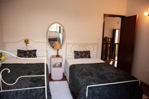 a bedroom with two beds and a mirror at Casa Senhor da Ponte in Mondim de Basto +5 photos