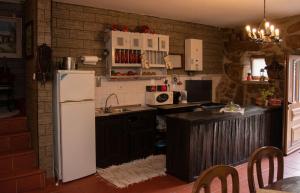 a kitchen with a white refrigerator and a sink at Casa Senhor da Ponte in Mondim de Basto
