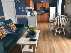 a living room with a green couch and a table at Whispering Waves Cottages in Shelburne