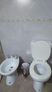 y baño con aseo blanco y lavamanos. en El Quincho en Gualeguay